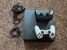 PS4 with 2 controllers, earbud headset, and controller charger