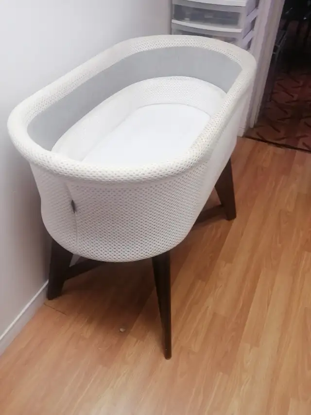 White bassinet with wooden legs