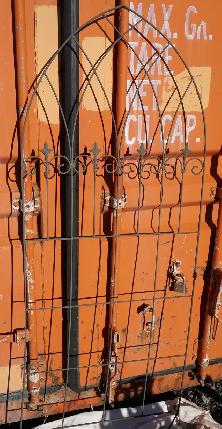 Solid wrought iron garden trellis with fleur-de-lis decoration.