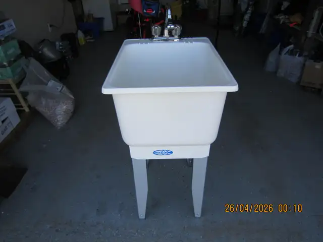 Laundry tub with taps and spayer.