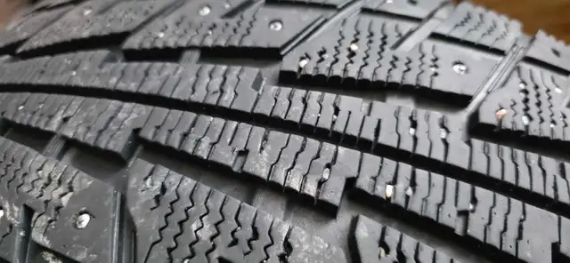 Aftermarket black 'DAI' rims with studded tires