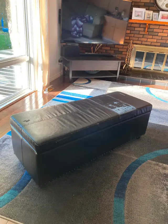 Fake leather storage bench with wear on the top.