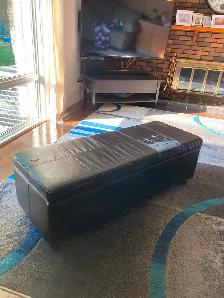 Fake leather storage bench with wear on the top.