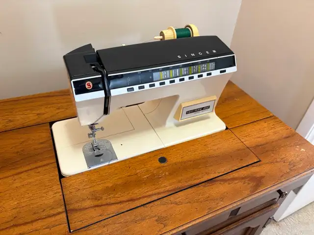 Singer sewing machine in cabinet with accessories