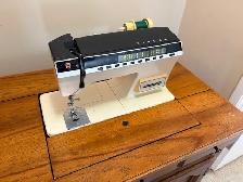 Singer sewing machine in cabinet with accessories