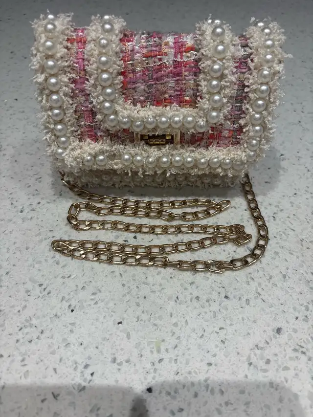 Pink purse white pearls and gold colored chain