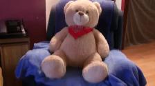 Gros ours en peluche, servait de décoration sur un lit