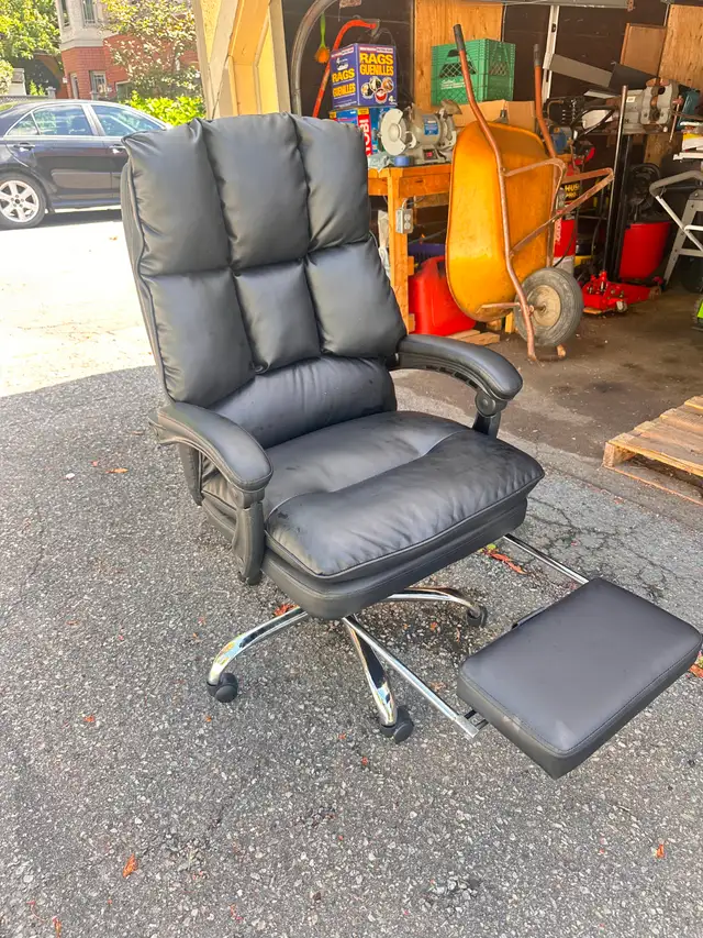 black adjustable office chair with hidden foot stool