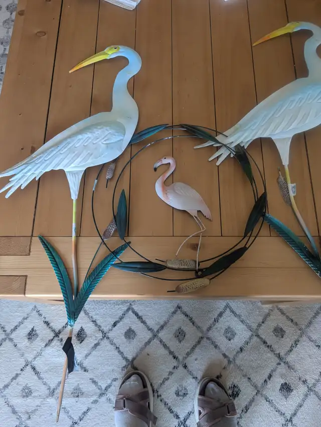 Two blue flamingos and one smaller pink one